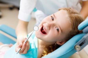 child with her teeth being cleaned at the dentist office